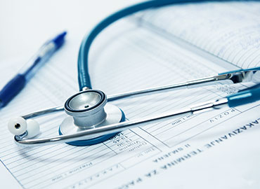 Stethoscope and pen sitting on medical chart. Banner for website behind category buttons.