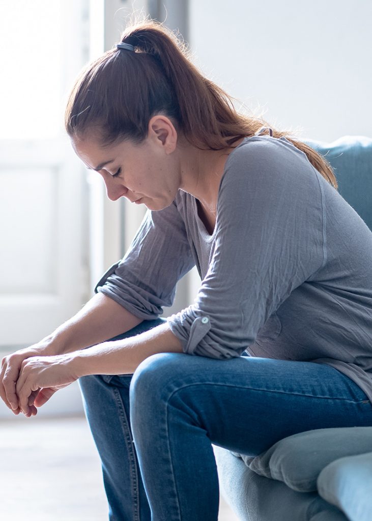 Young attractive latin woman lying at home living room couch feeling sad tired and worried suffering depression in mental health, problems and broken heart concept