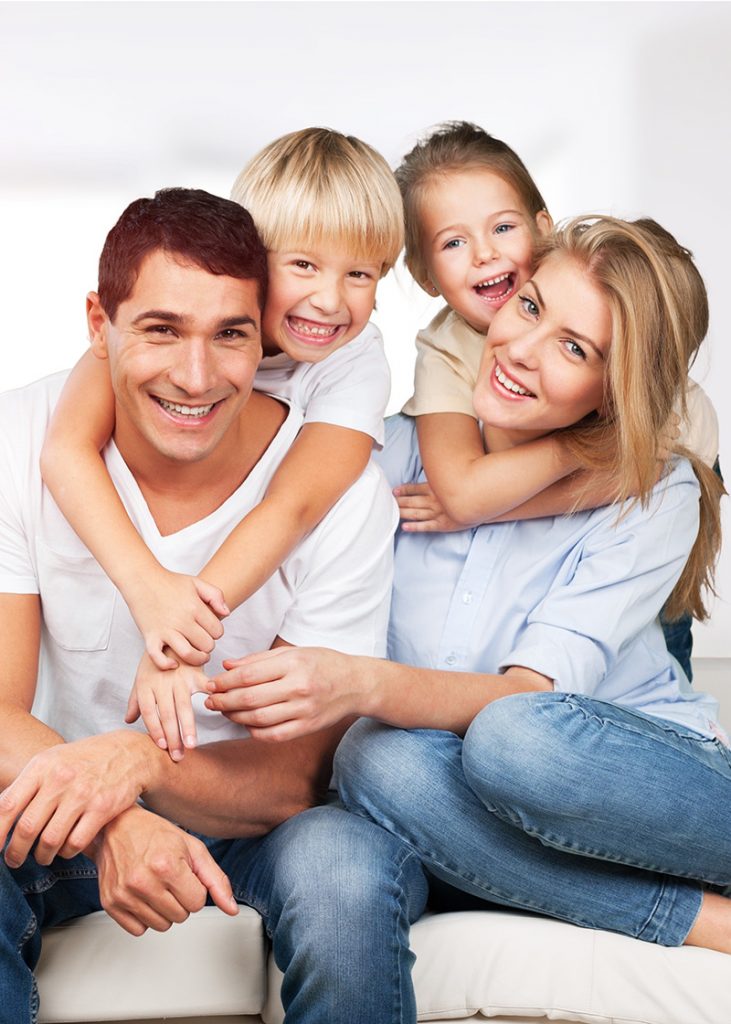 Young white family at home smiling at camera